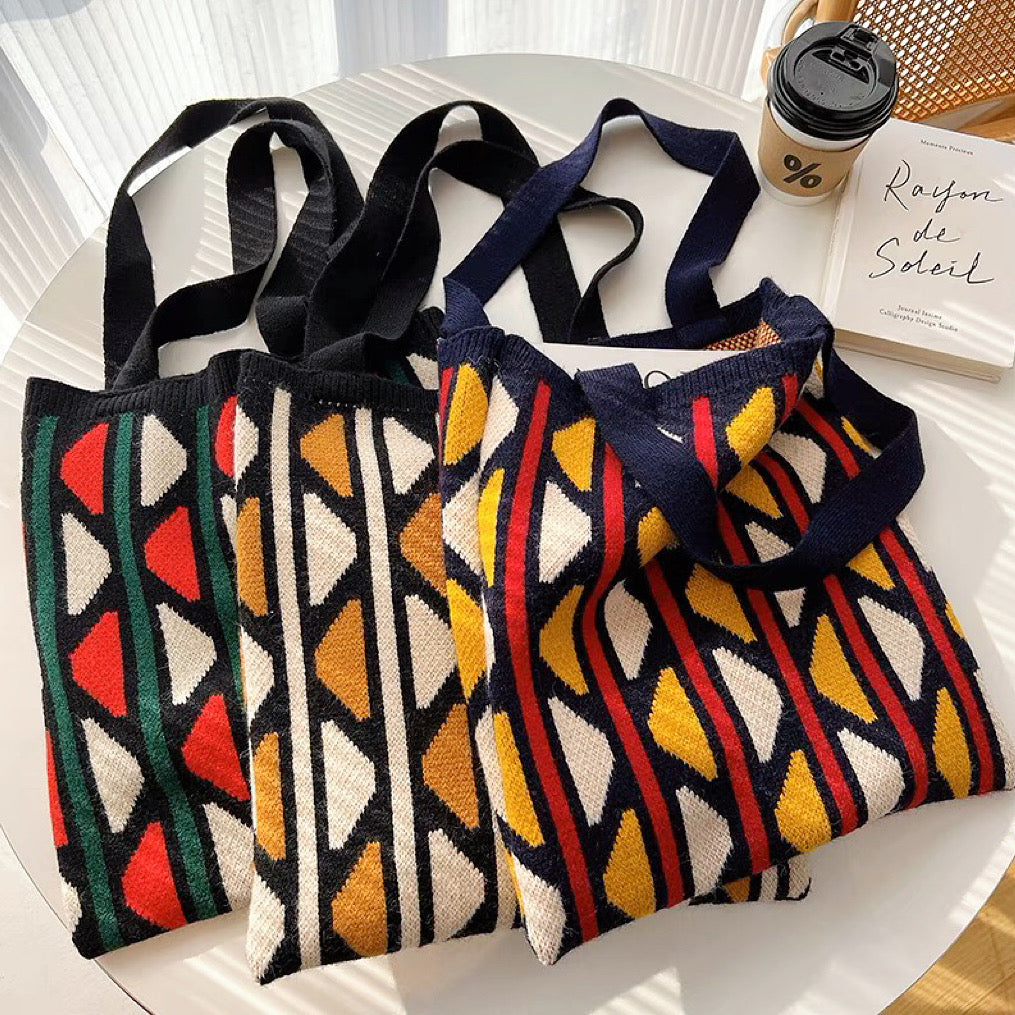 Front view of Three  knitted tote bags with geometric contrast color patterns .