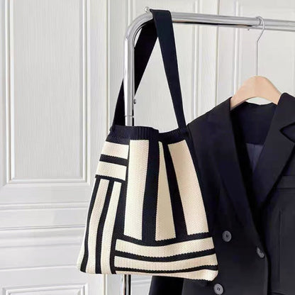 Front view of black Geometric Line Knitted Bag hanging on a hanger , great for everyday carry and travel.