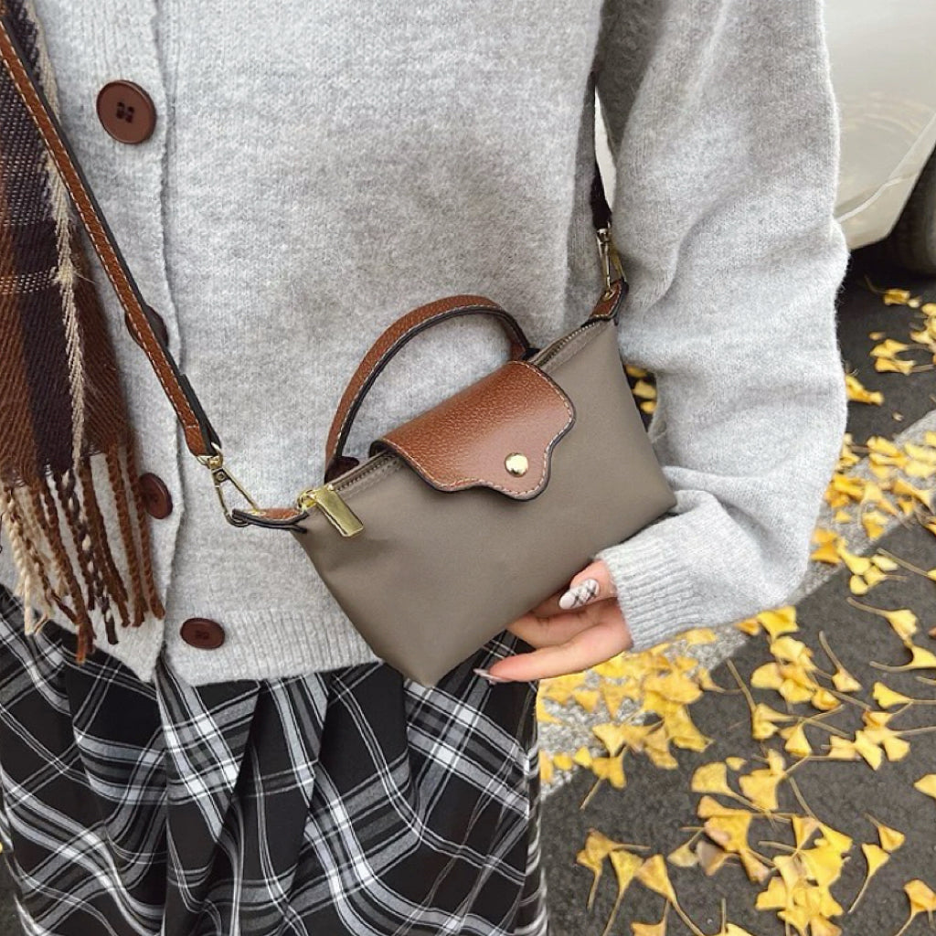 Model wearing the grey nylon mini bag, showing its dainty profile.