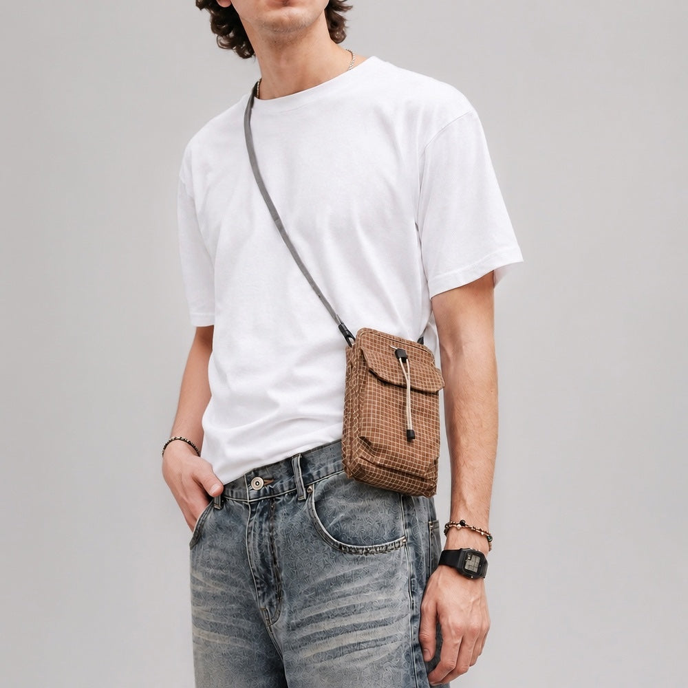 Male model wearing the grid magnetic utility pouch in brown over a plain white t-shirt.