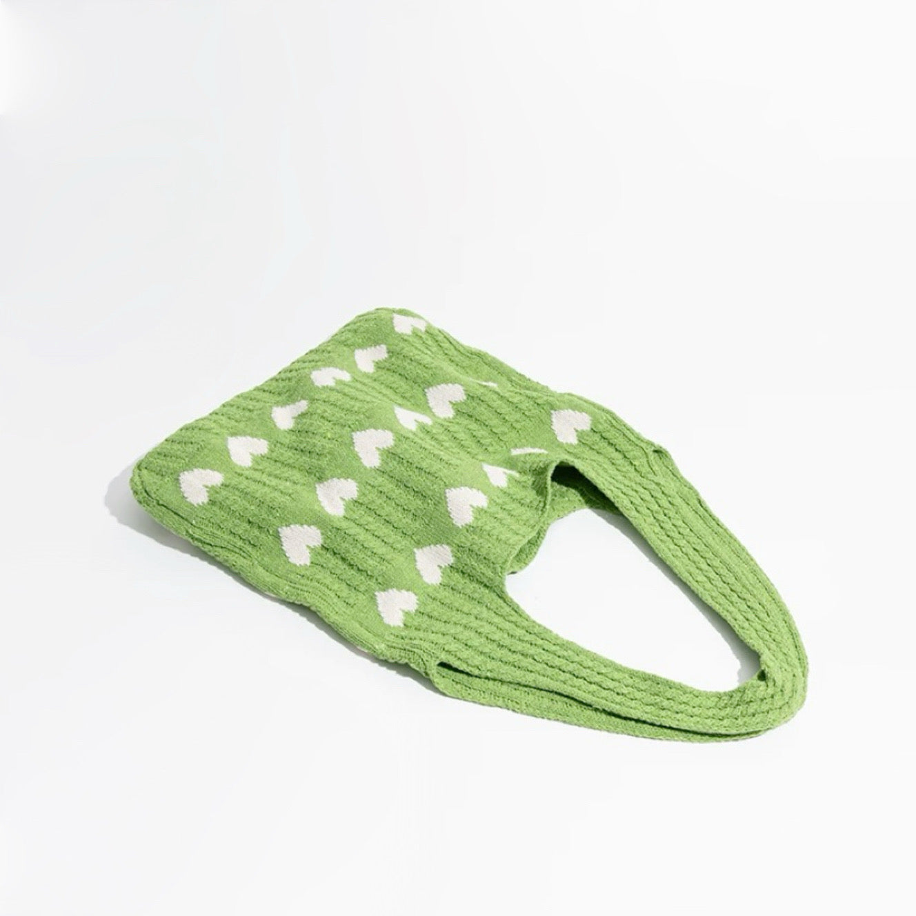 Green blended knitting yarn crochet bag with white heart pattern and short straps.