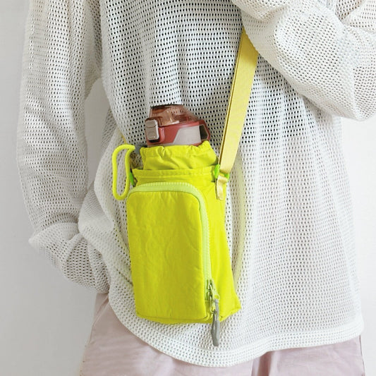 A model styling a neon yellow hydration pouch for hiking, emphasizing visibility and water-resistant nylon fabric.