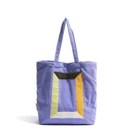Front view of Lavender corduroy tote bag with colorful geometric panel design and two grab straps in lilac