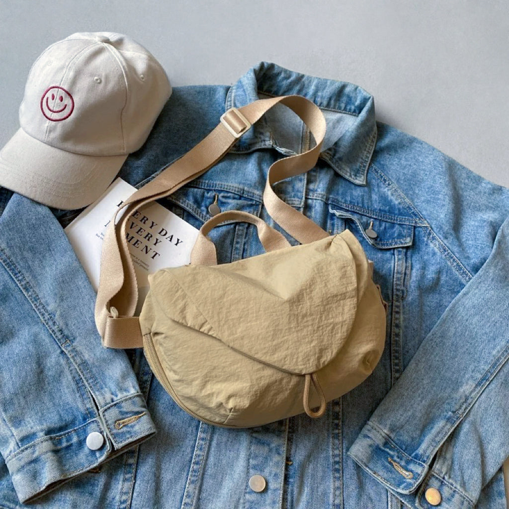 Khaki crinkle bag paired with a baseball cap and denim for a perfect travel kit.