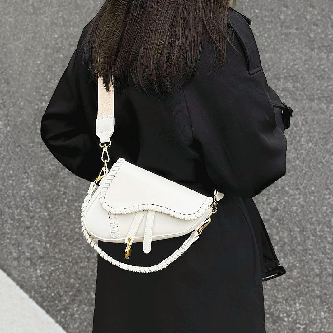 Model carrying a Threaded Saddle Bag in white as crossbody, ideal for city walks and gifting.