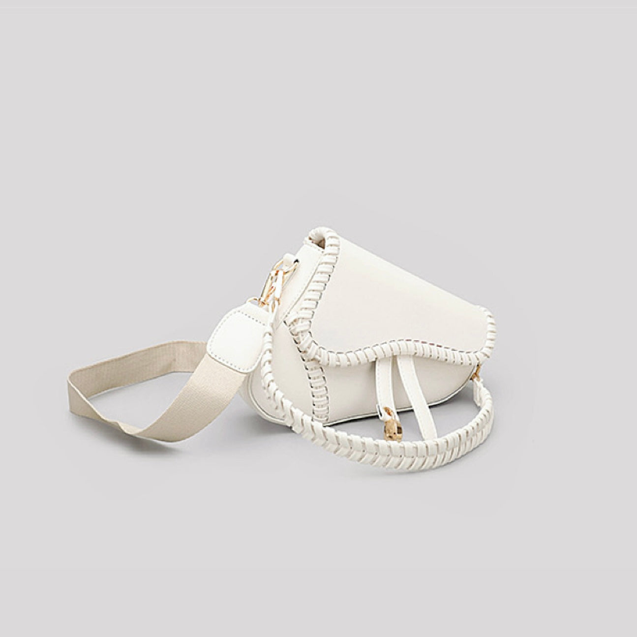 Folded view of Leather Threaded Saddle Bag in white, easy for commuting and weekends.