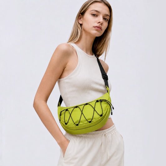 A women wearing a lemon green nylon sling bag as crossbody, showcasing sleek crescent silhouette and water-resistant fabric.