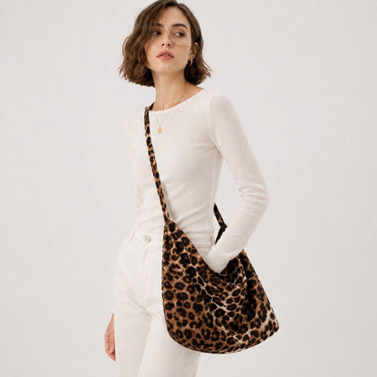 Model styling the casual leopard print leisure tote bag across her chest paired with casual denim.
