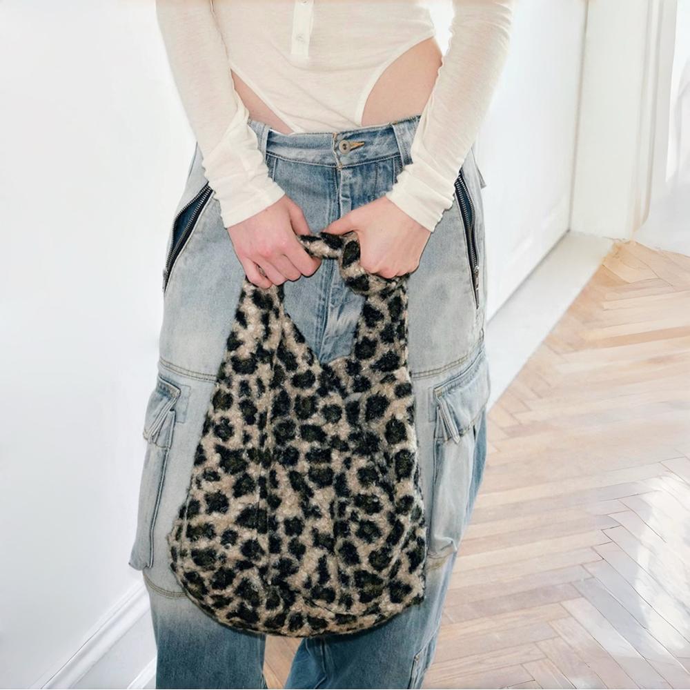 Model carrying a khaki leopard print polyester tote bag handheld, great for daily carry and travel.