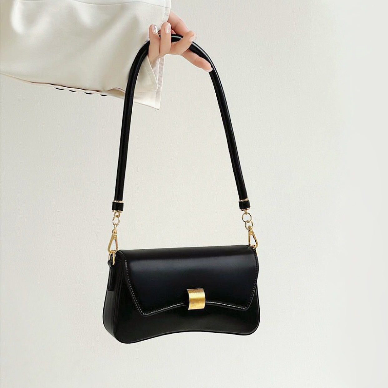 Folded view of Light Leather Arc Baguette Shoulder Bag in black, easy for commuting and weekends.