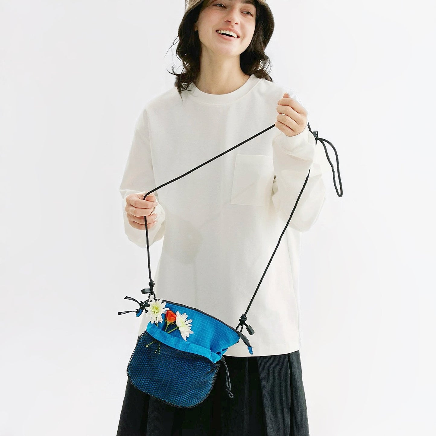 Model holding the blue Mesh Vogue Crossbody Bag, easy for commuting and weekends.