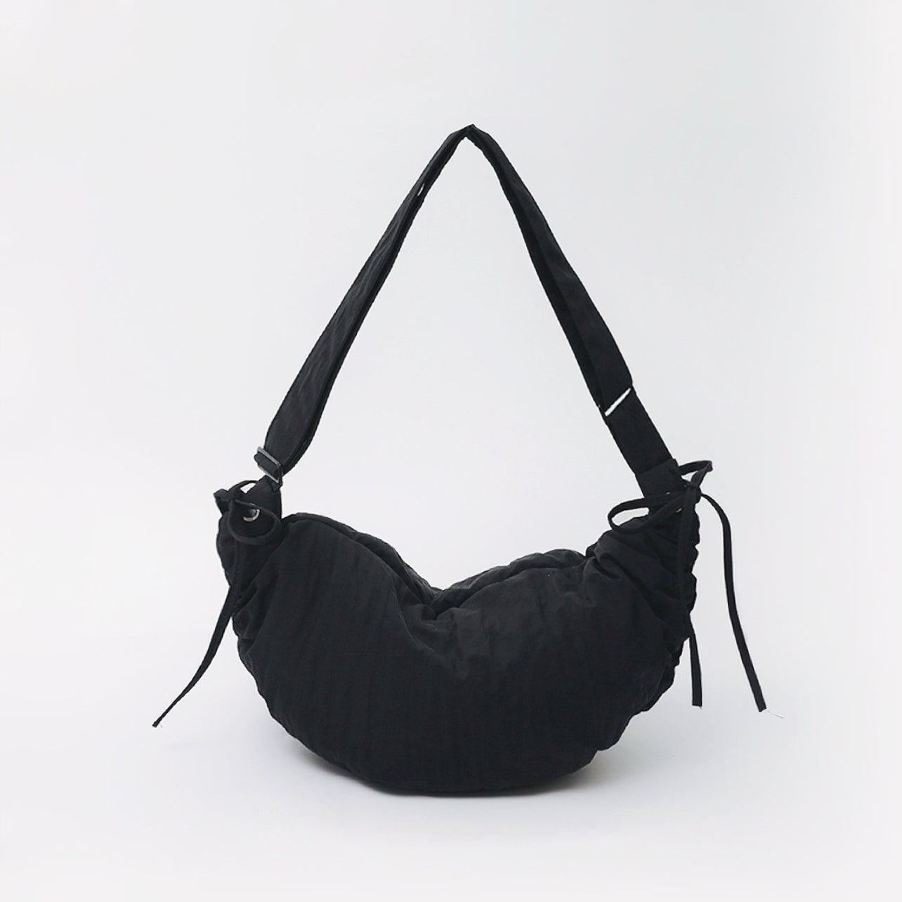 Classic black mini duvet crescent bag highlighting its sleek padded silhouette.