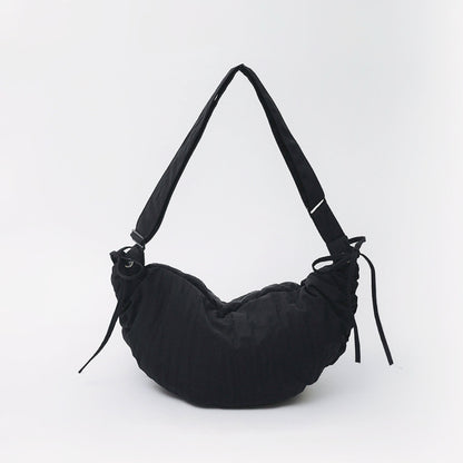 Classic black mini duvet crescent bag highlighting its sleek padded silhouette.