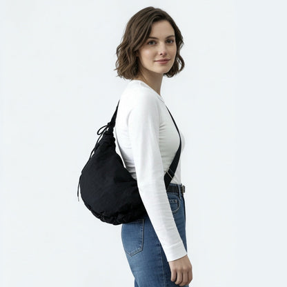 Model styling the black duvet crescent bag with a streetwear outfit.