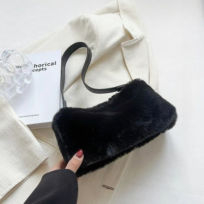 Close-up of Black mini shearling baguette bag with a shoulder strap and zip-top fastening shoulder bag.