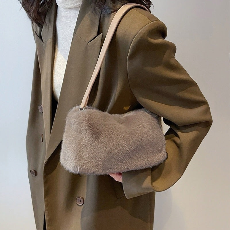 Model carrying a khaki mini fluffy shearling baguette bag  on the shoulder, easy for commuting and weekends.