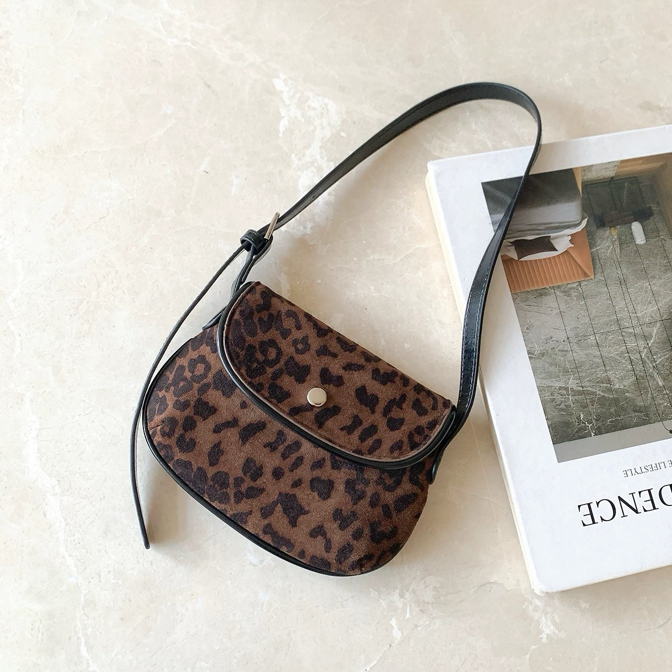 Front view of the dark leopard print mini suede saddle bag on a clean background.
