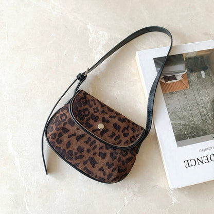 Front view of the dark leopard print mini suede saddle bag on a clean background.