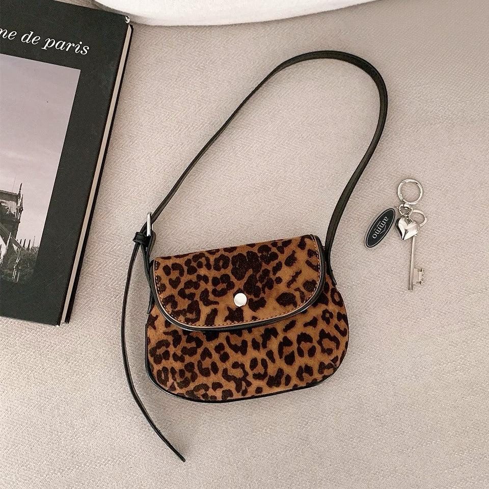 Front view of the leopard print mini suede saddle bag on a clean background.