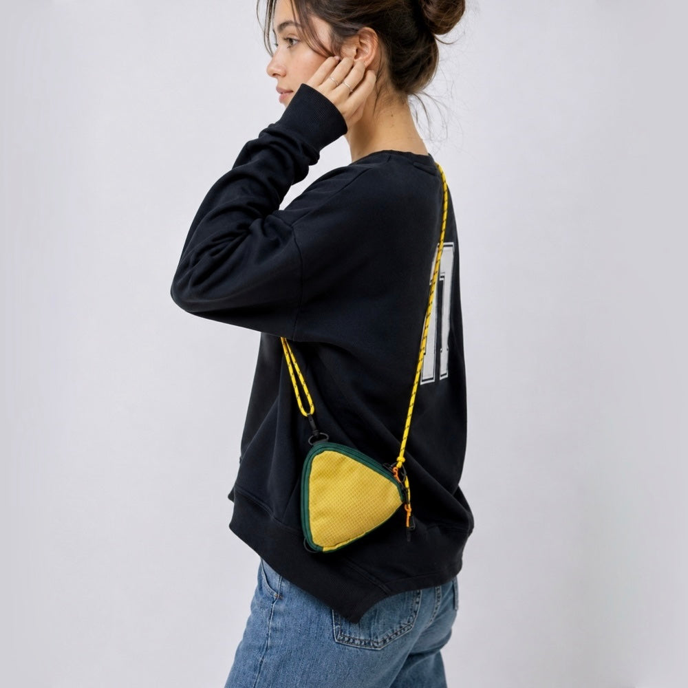 A model wearing a yellow triangle mini bag as a crossbody, highlighting the geometric style impact.