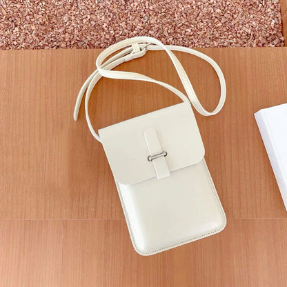 Close-up of Minimalist off-white PU leather crossbody bag with loop-through closure and long strap