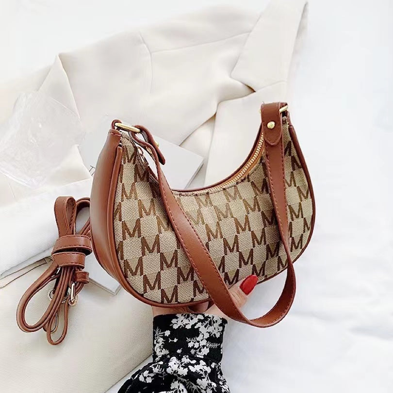 Close-up of Monogram Crescent Shoulder Bag in brown, great for everyday carry and travel.