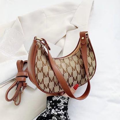 Close-up of Monogram Crescent Shoulder Bag in brown, great for everyday carry and travel.