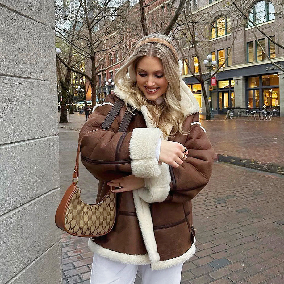 Model carrying a brown Monogram Crescent Bag  in hand, easy for commuting and weekends.