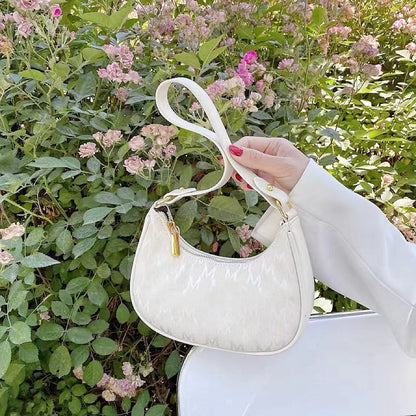 Model carrying a white Monogram Crescent Bag handheld,.
