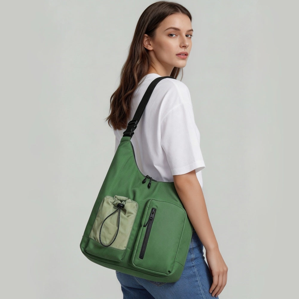 Model wearing a green multi-pocket nylon bag on shoulder.