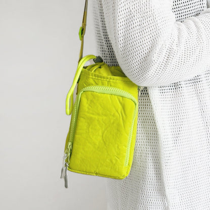 A woman styling a neon yellow bottle bag for a spring City Walk