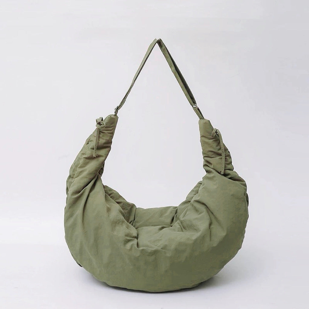 Front view of the olive green puffy crescent bag with a comfortable wide shoulder strap.