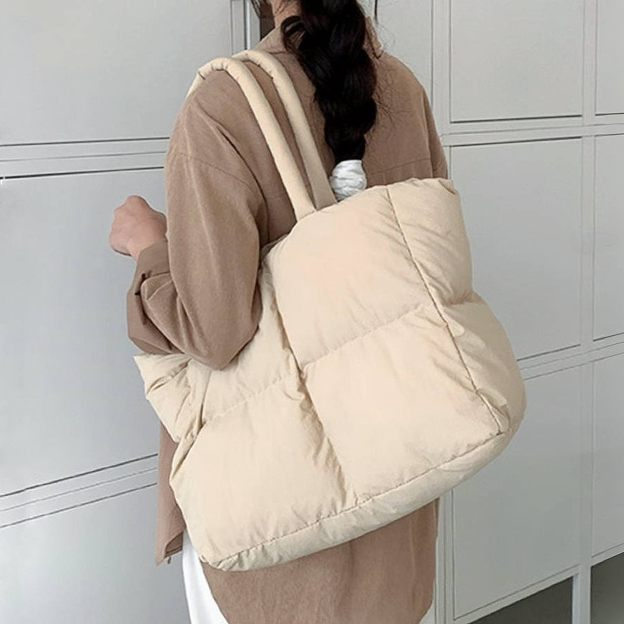 Back view of the apricot padded tote bag worn on the shoulder.