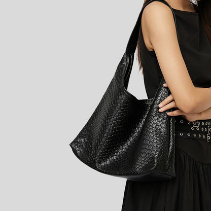Side view of the black pebble leather bag being worn on the shoulder.