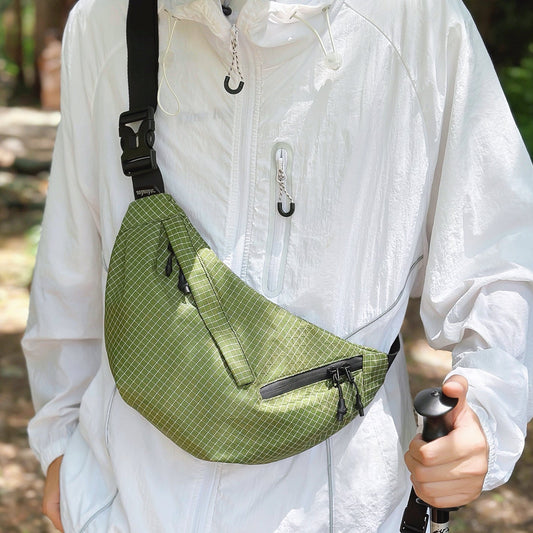 Model carrying a green plaid nylon sling bag as crossbody, great for daily carry and travel.