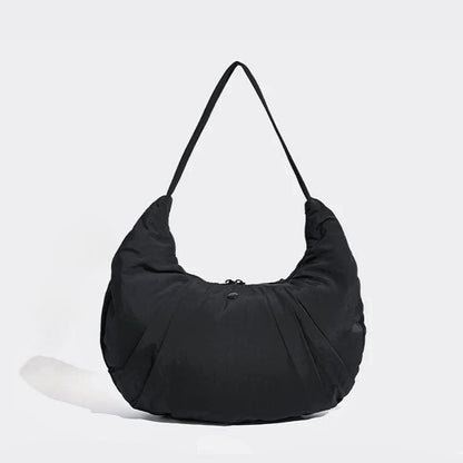 Angled view of Pleated Crescent Shoulder Bag in black, great for everyday carry and travel.