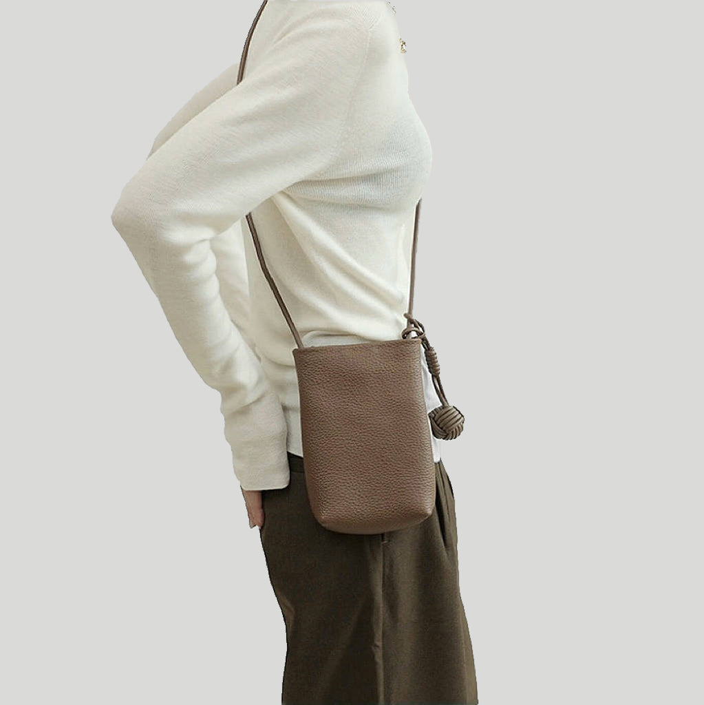 Model wearing the brown leather bag over a white sweater, elegant daily style.