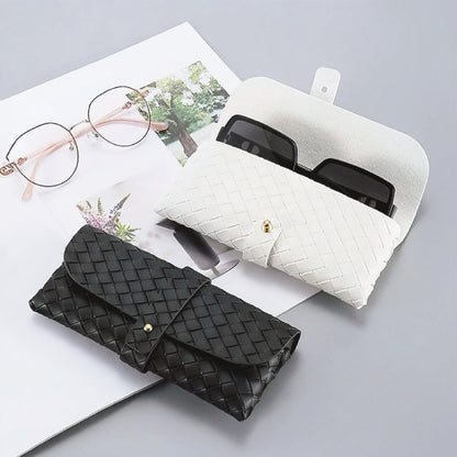 Angled view of two Portable Woven Leather Glasses Case show together, black is close and white is open.