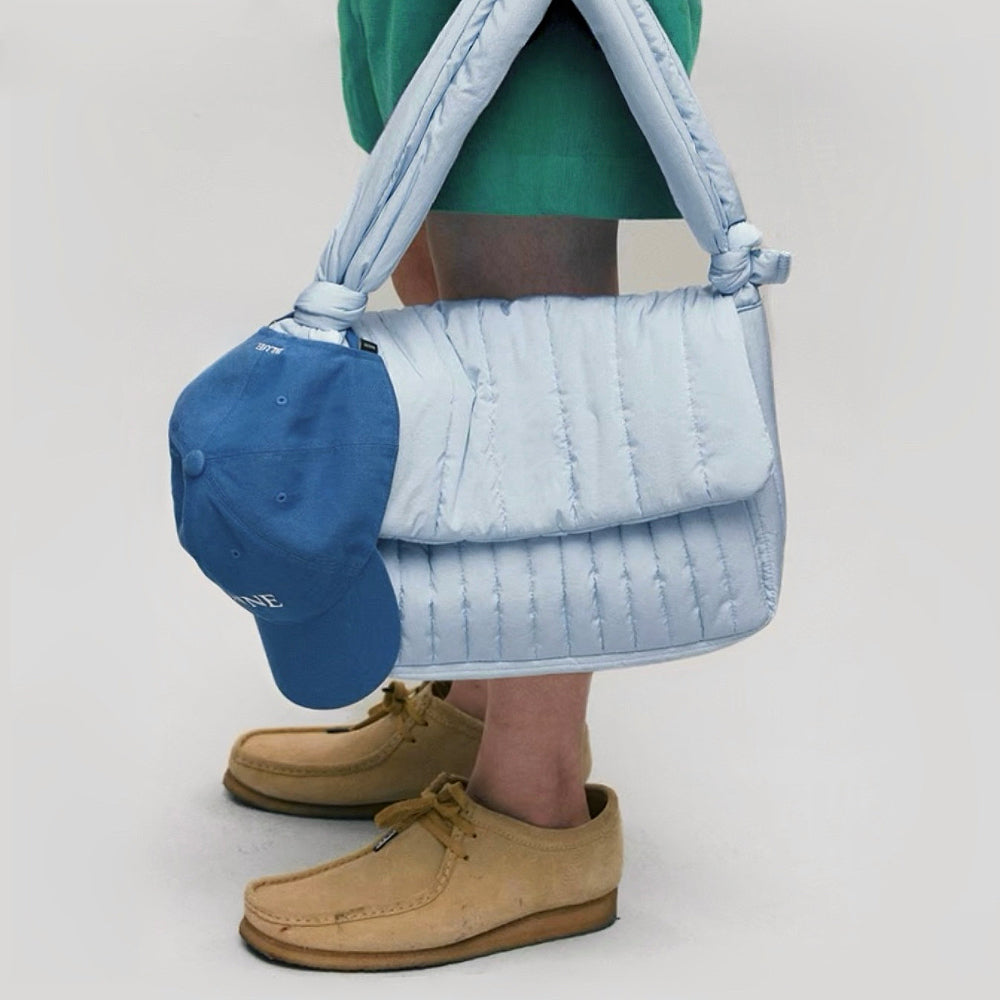 Model carrying a polyester Puffy Knot Quilted Baghandheld , great for daily carry and travel.