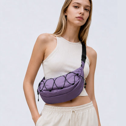 A women wearing a lilac purple  nylon sling bag as crossbody, showcasing sleek crescent silhouette and water-resistant fabric.