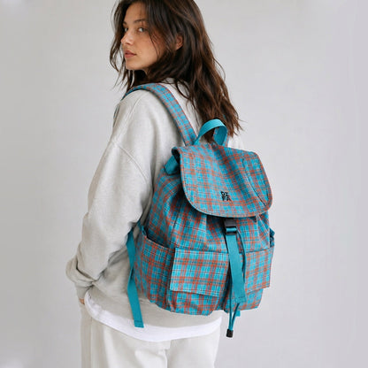 Back view of a model wearing the blue plaid nylon school bag showcasing padded shoulder straps.