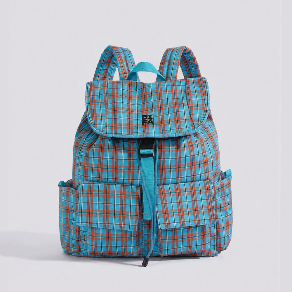 Studio flat lay of the blue and orange retro colorblock plaid nylon backpack showing front buckle flap pockets.