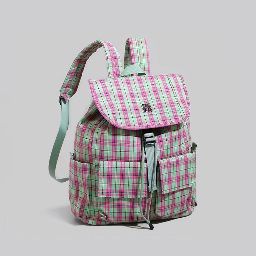 Three-quarter studio display of the pink and green colorblock plaid backpack showing padded construction.