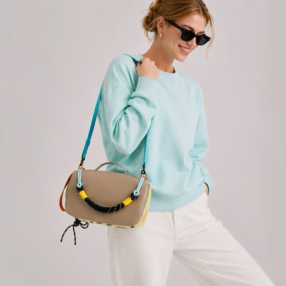 Model styling the khai reversible colorblock utility bag on her shoulder.