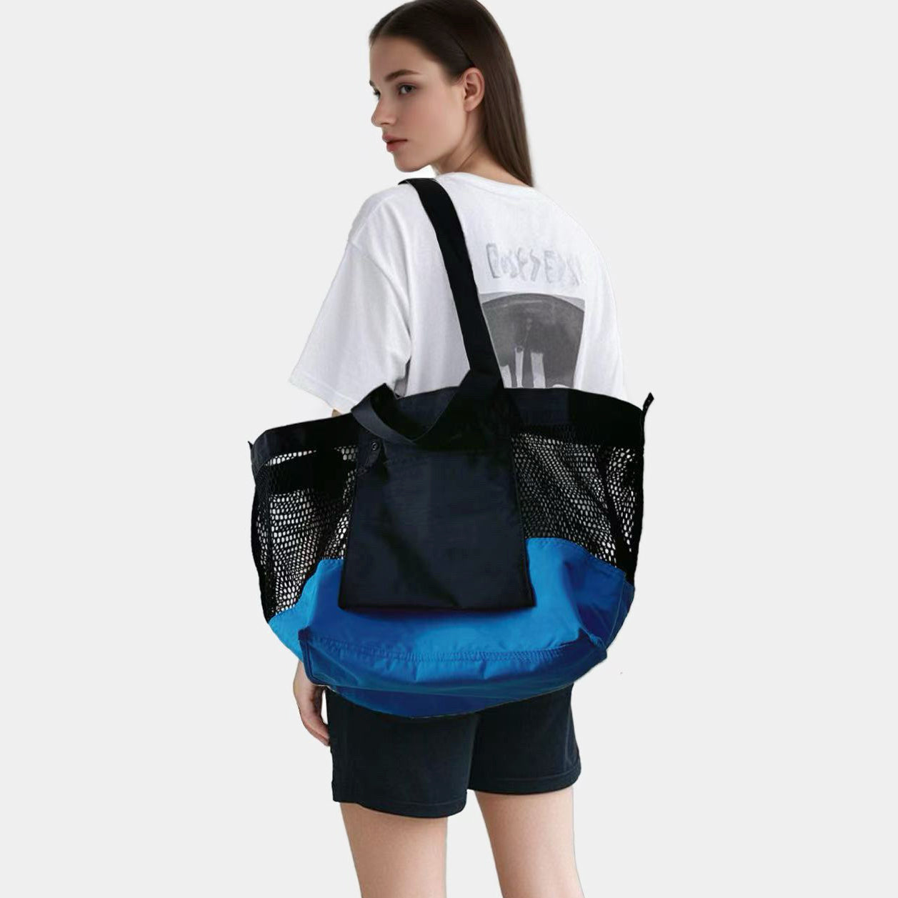 Back view of a model carrying the blue and black double-sided tote bag.