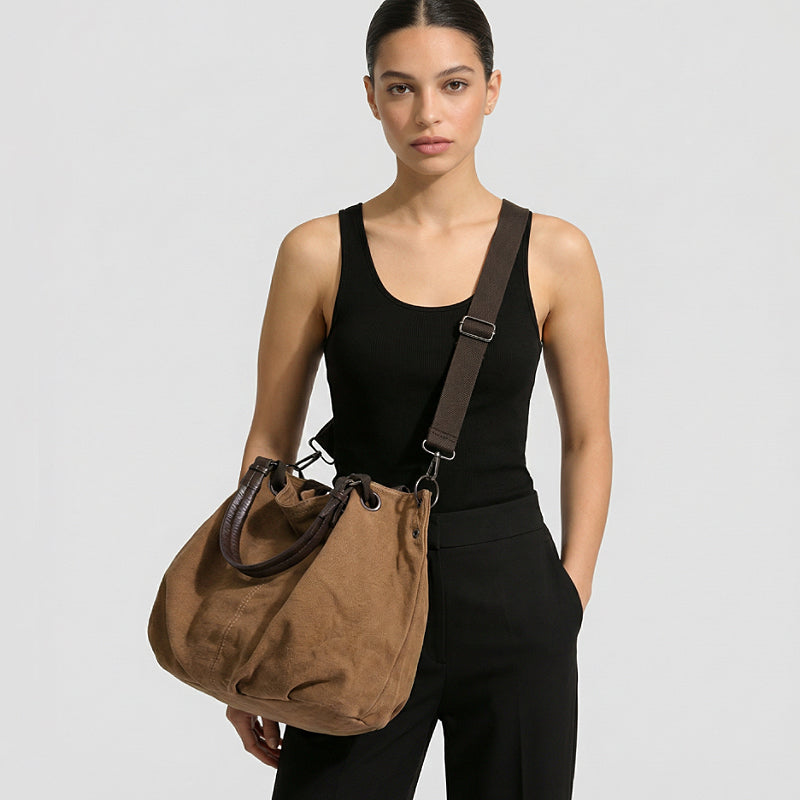 Model carrying the brown canvas tote bag crossbody style.
