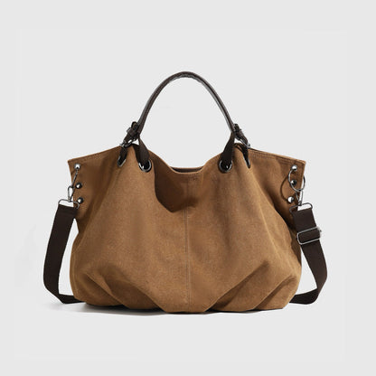 Front view of the brown rugged cargo canvas tote bag with leather trim.