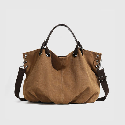 Front view of the brown rugged cargo canvas tote bag with leather trim.