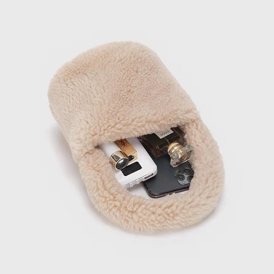 Angled view of apricot sherpa bucket handbag with phone, perfume, and lighter inside, easy for commuting.