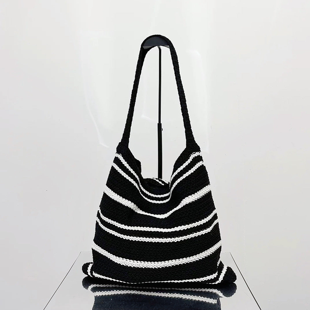 Angled view of Simple Striped Knitted Bag in black and white, great for everyday carry and travel.
